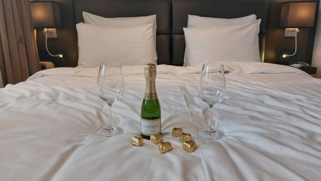luxury hotel bed with cava and chocolates